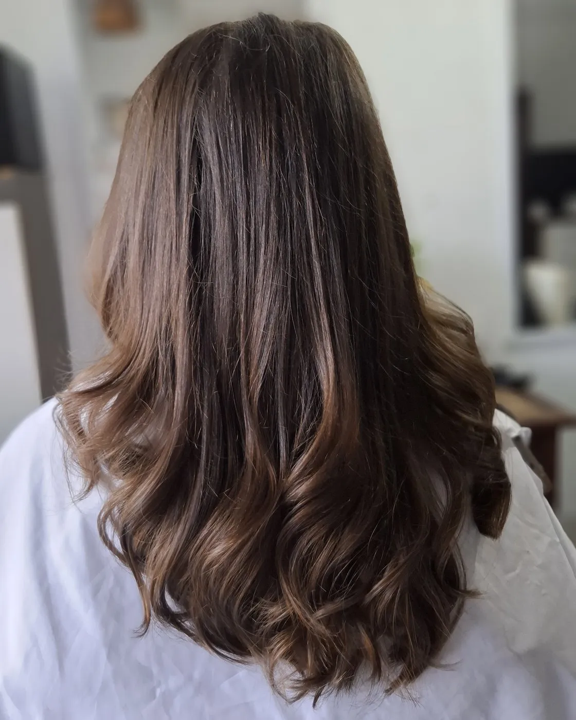 Brown hair blow dried into soft waves, seen from behind