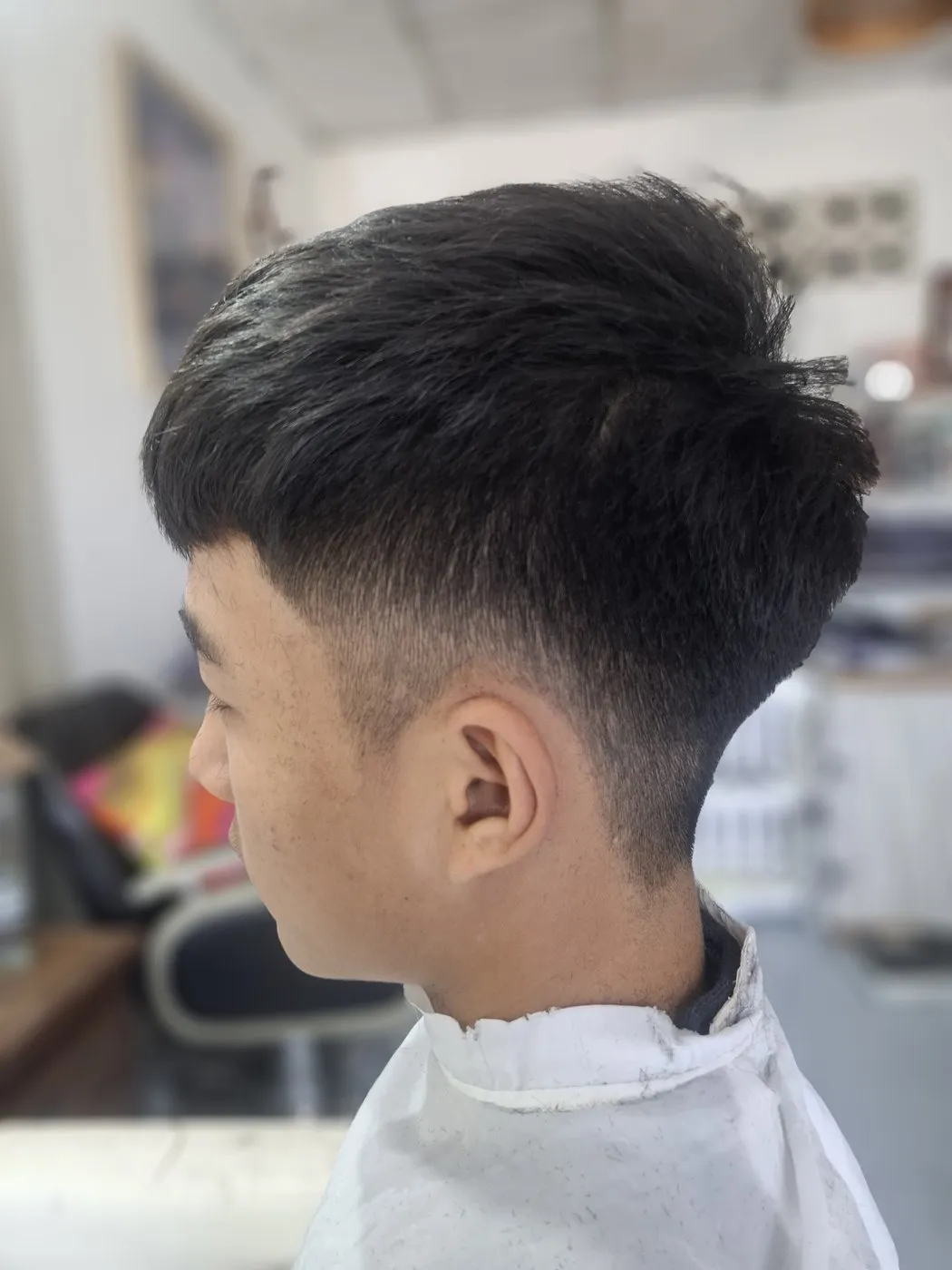 Short men’s cut with a fade at the sides, seen from the side